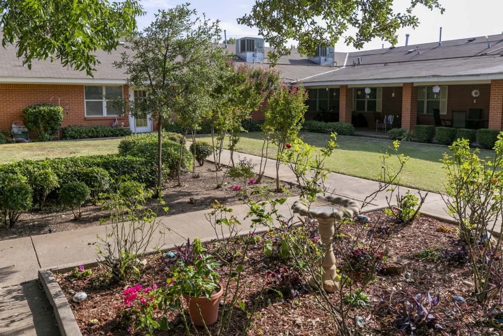A beautifully landscaped garden with a pathway and various plants and trees.