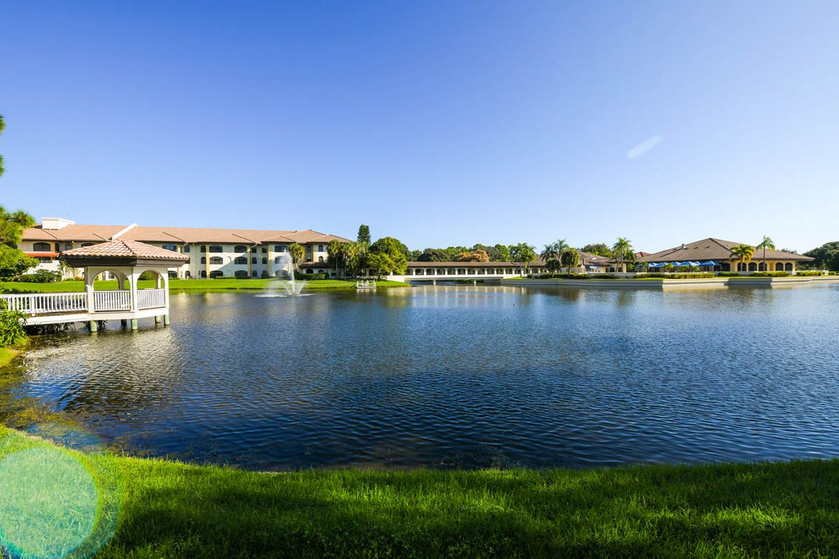 A serene resort by the lake under a clear blue sky.