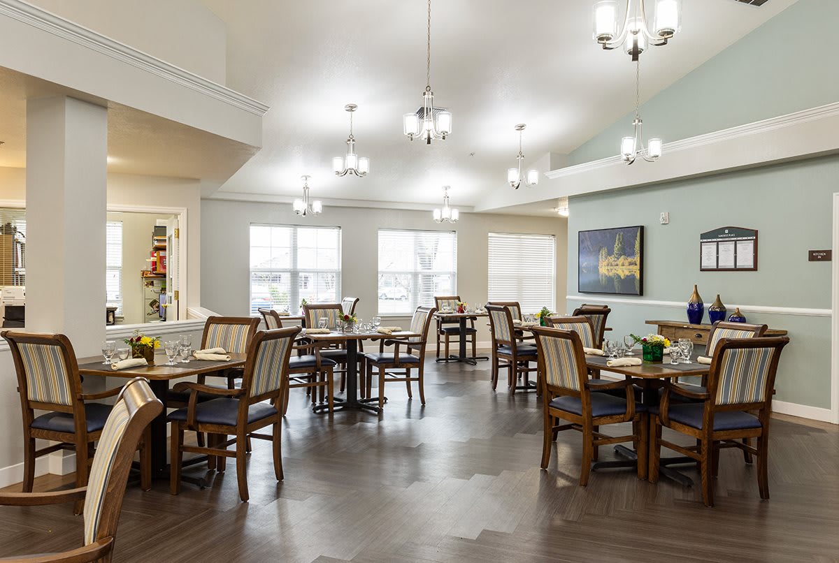 A spacious dining room with elegant lighting and neatly arranged tables and chairs.