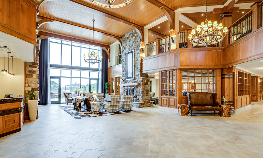 Spacious lobby with elegant interior design, featuring a large stone fireplace and chandelier.