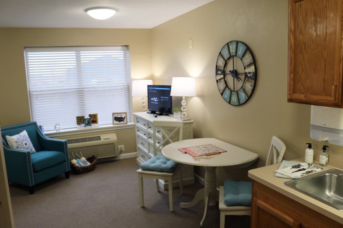 Cozy living room with a small dining table and decorative clock.