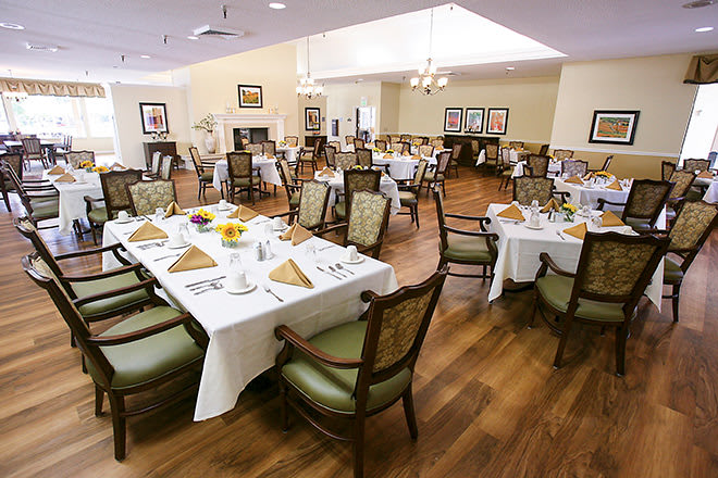 An elegantly decorated dining room with neatly arranged tables and chairs, ready for guests.