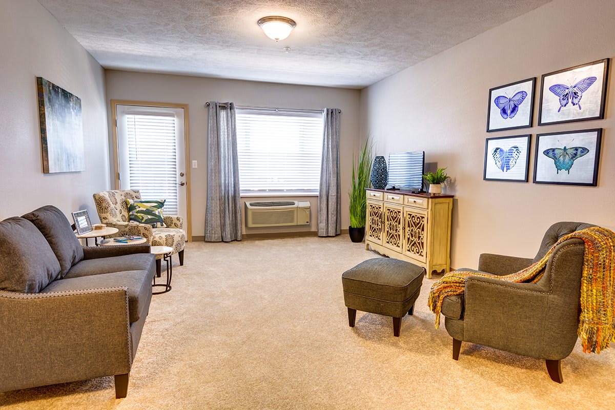 A cozy living room with neutral tones, featuring a sofa, television, and a coffee table.