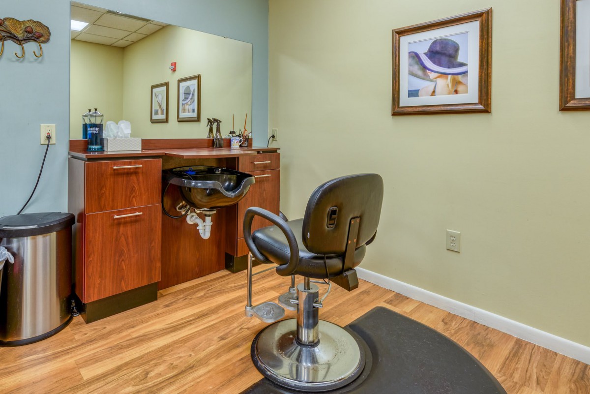 A cozy salon interior featuring a barber chair, mirror, and stylish decor.