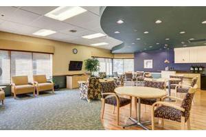 A spacious waiting area with comfortable seating and a television.