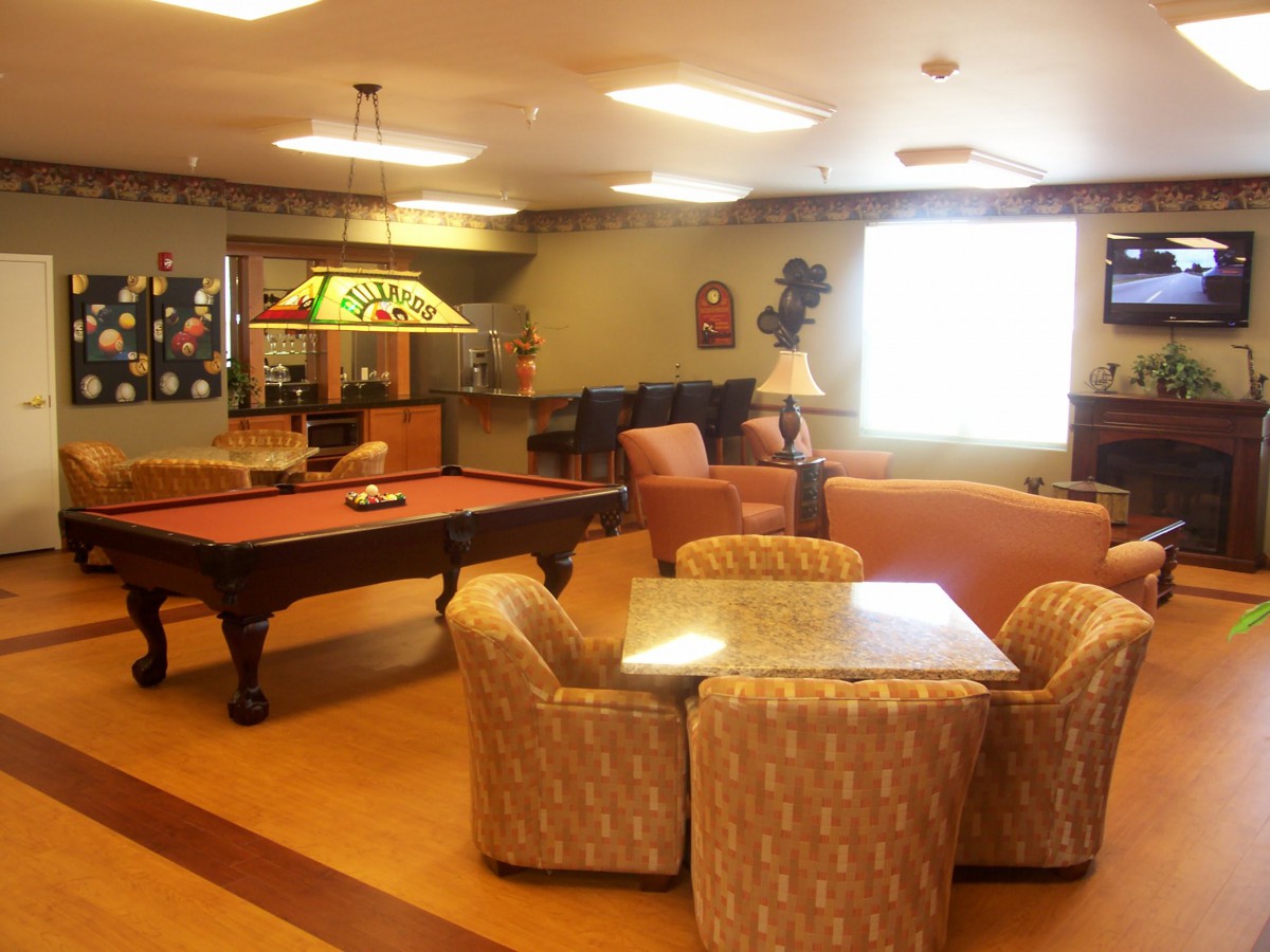 A cozy game room featuring a pool table and comfortable seating area.