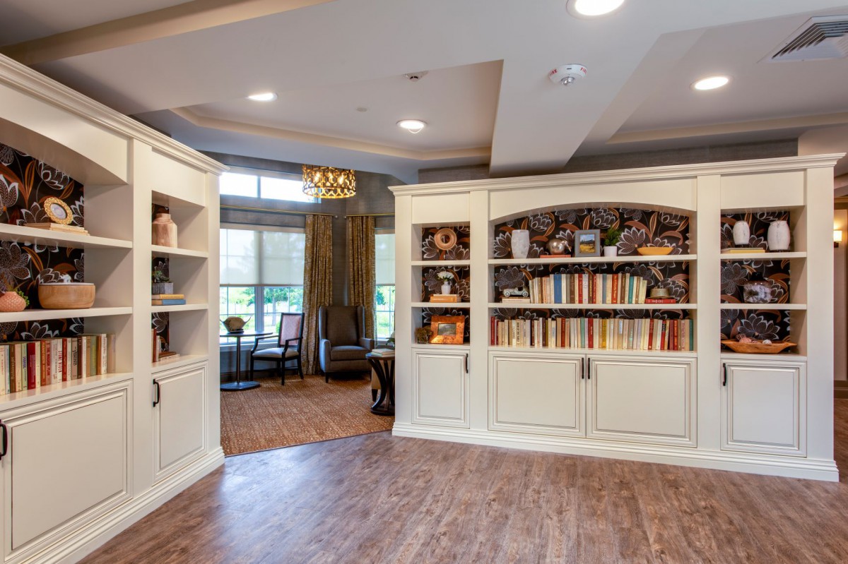A cozy living room with elegant bookshelves and warm wood flooring.