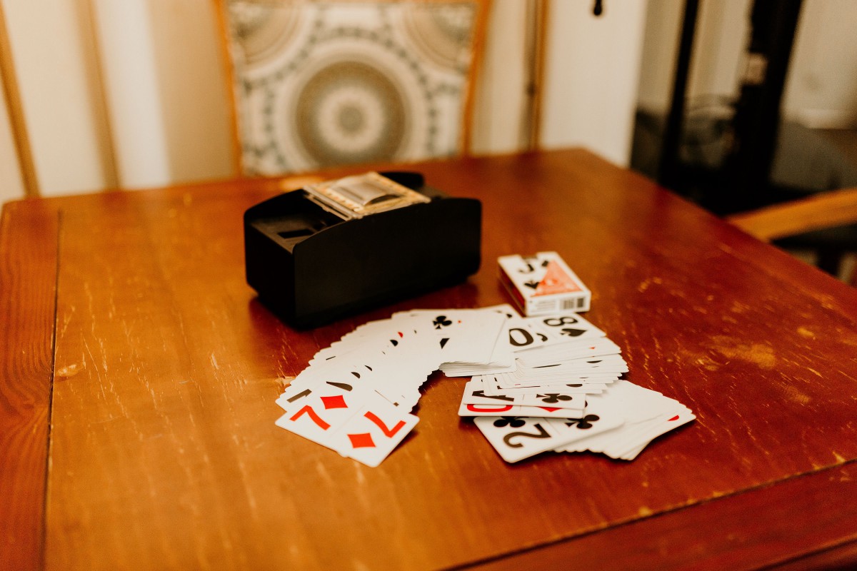 A deck of playing cards scattered on a wooden table, ready for a card game.