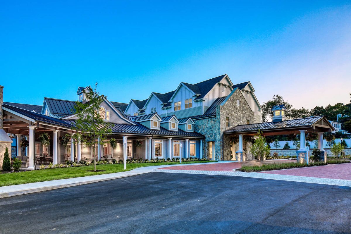 A large residential building with a stone exterior and surrounding greenery.