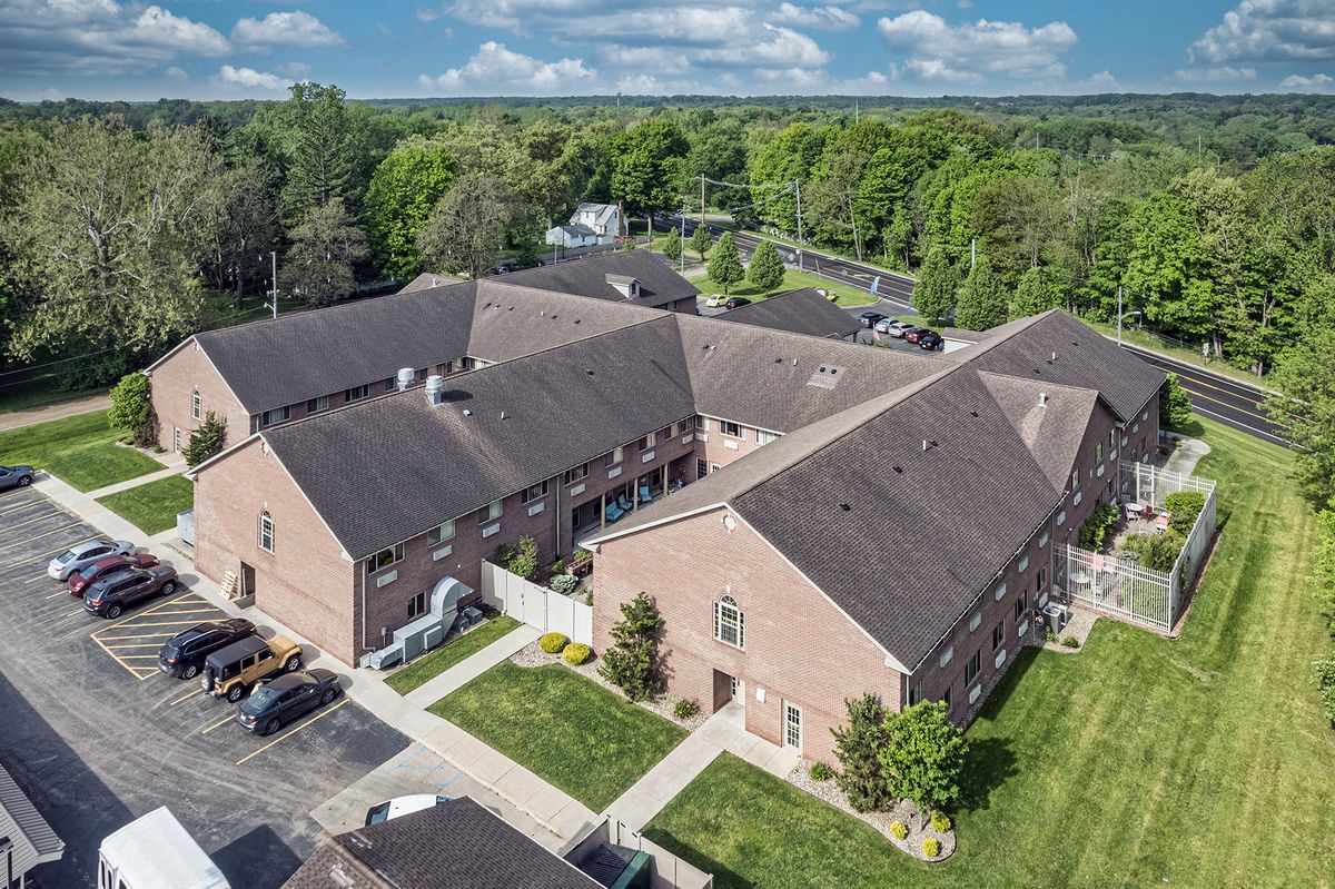 Aerial view of a residential brick apartment complex with surrounding greenery.