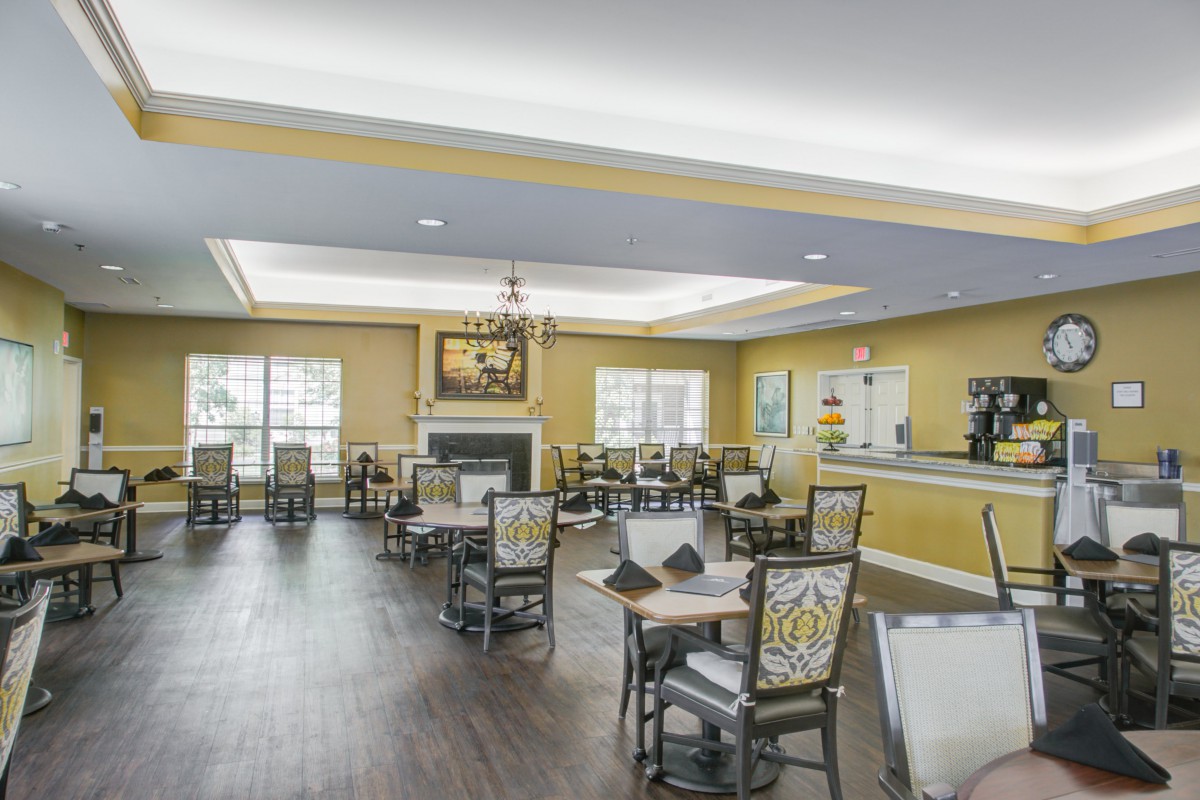 A spacious and elegantly decorated dining room with tables, chairs, and a fireplace.