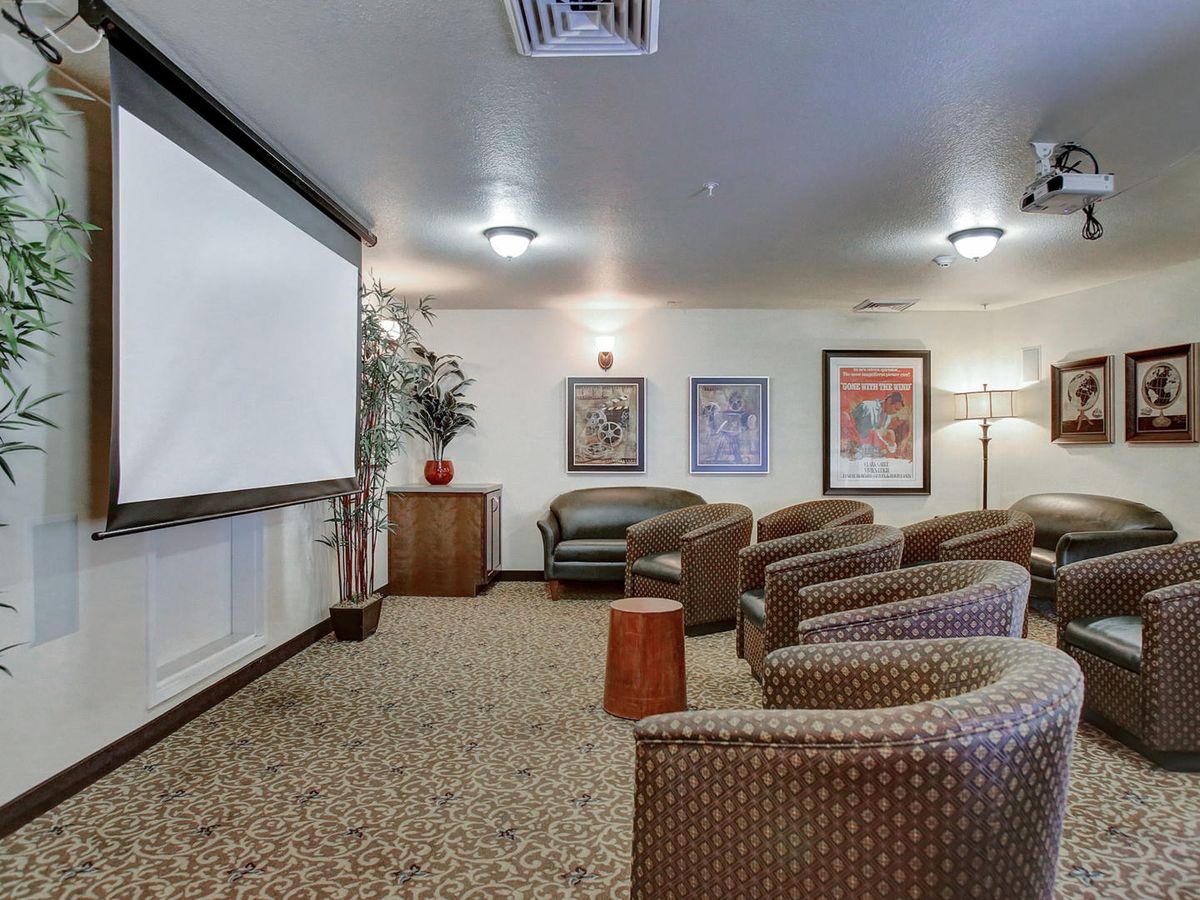 A cozy home theater room with comfortable seating and a large projector screen.
