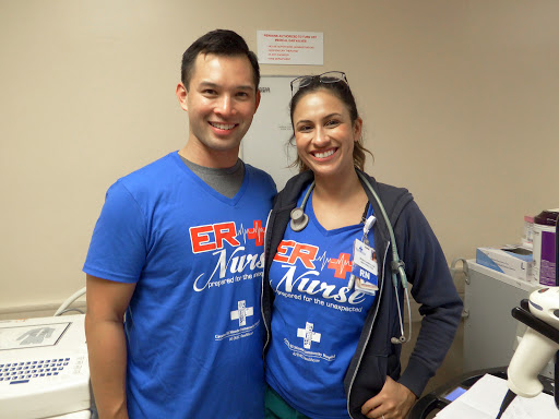 Two enthusiastic nurses posing together in their ER uniforms.