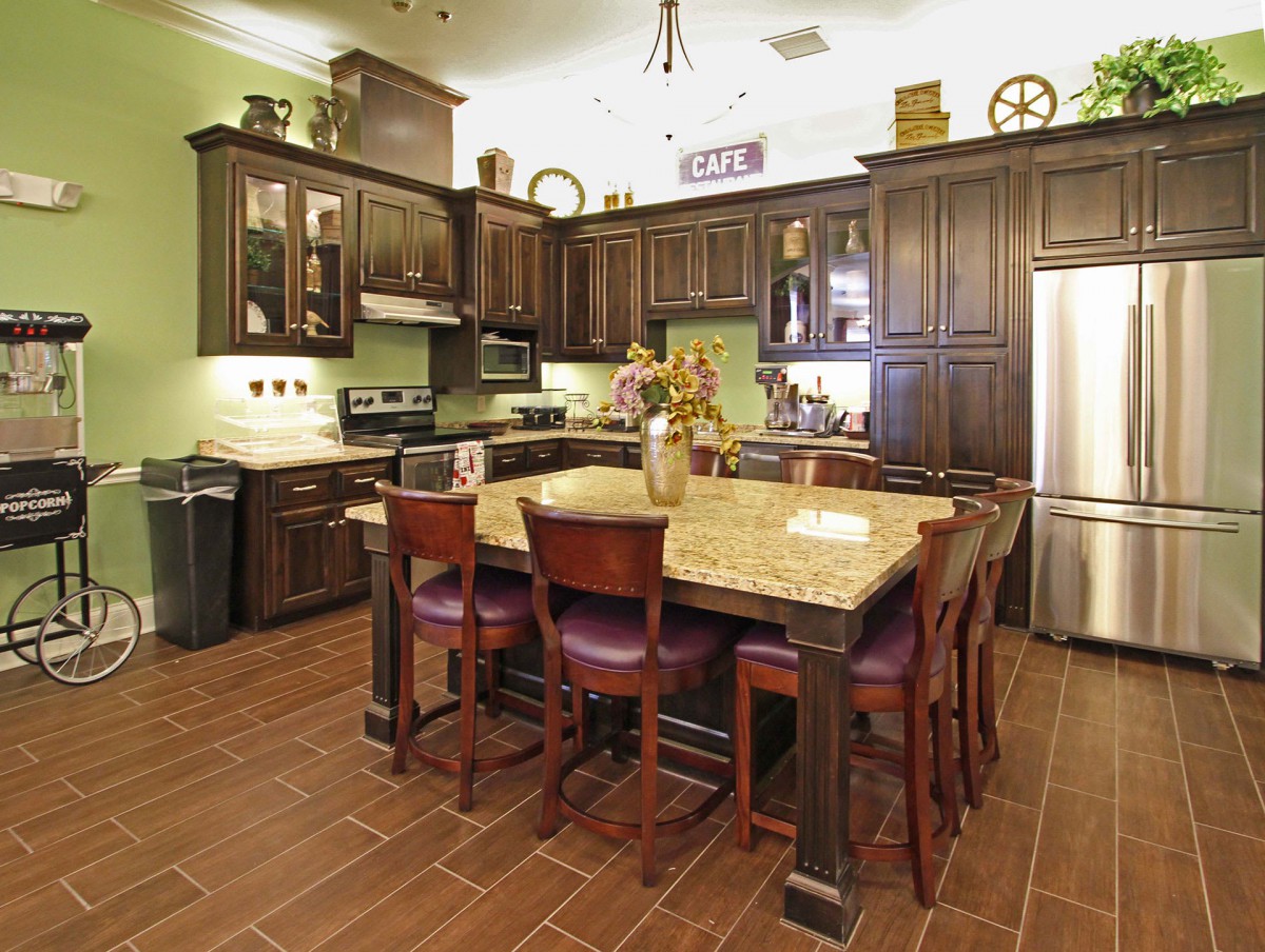 A spacious kitchen with dark wood cabinets and a large island.