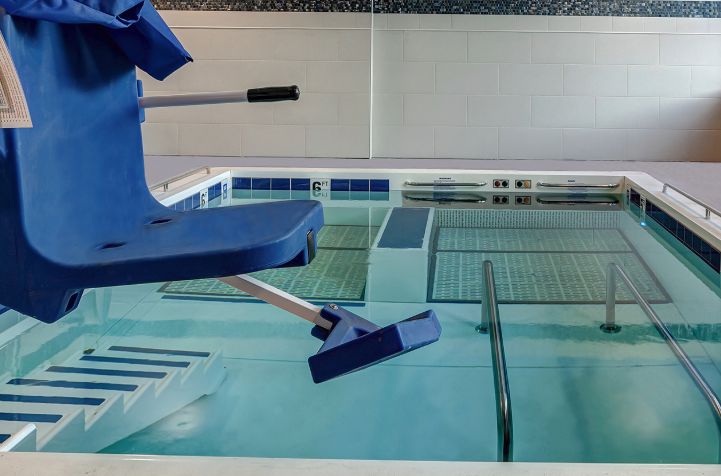 An indoor swimming pool equipped with an accessibility wheelchair lift for easy access.