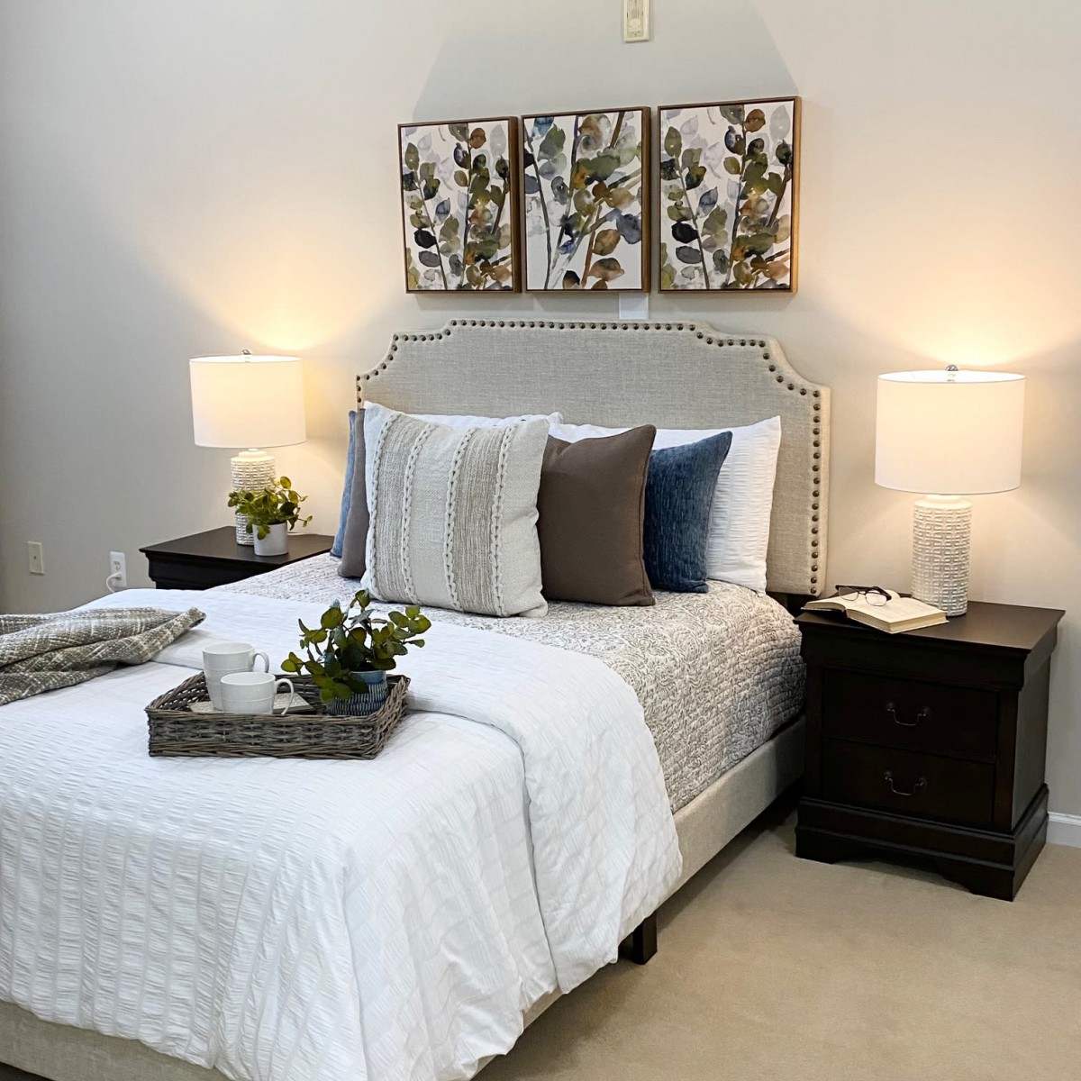 A cozy and modern bedroom with elegant decor, featuring a neatly made bed, stylish pillows, bedside lamps, and nightstands.