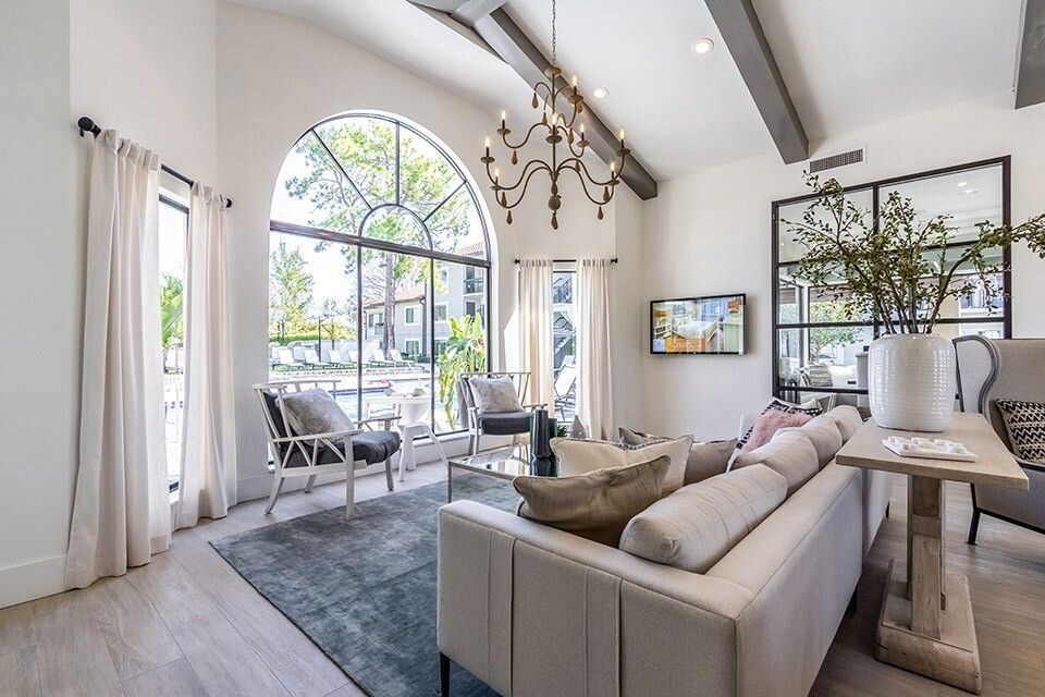 A modern living room with a large arched window and stylish furnishings.