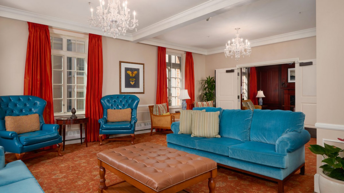 A luxurious living room with blue furniture and elegant chandeliers.