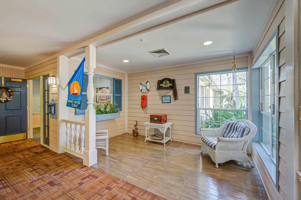 A cozy, decorated waiting area with seating and wooden flooring.