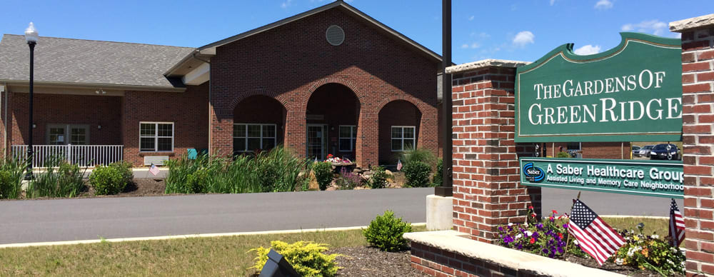 A brick building with an arched entrance surrounded by landscaping.