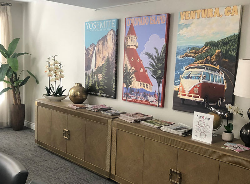 A stylish interior featuring vintage posters above a modern cabinet adorned with decorative items.
