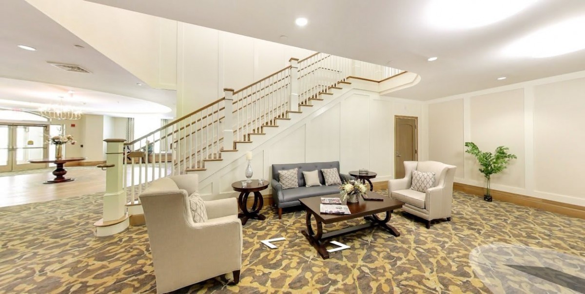 Elegant living room with a cozy seating area and stylish staircase.