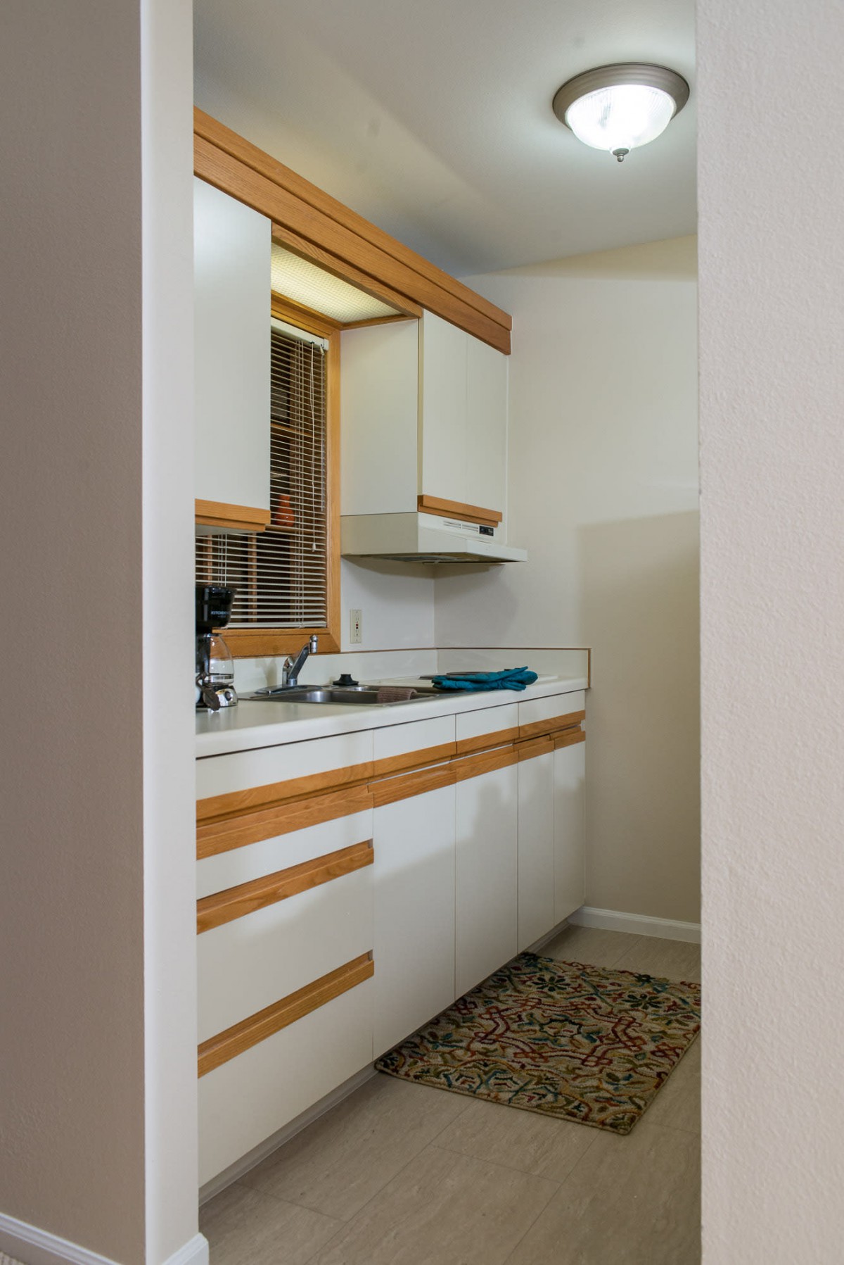 A modern kitchen with white cabinets and wood accents in a minimalist style.