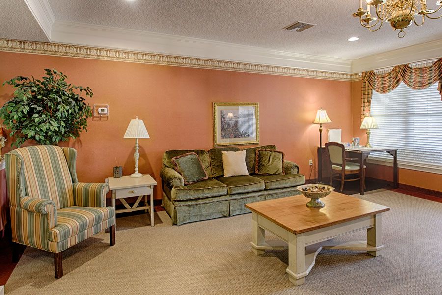 A traditional living room with a comfortable sofa, coffee table, and warm lighting.
