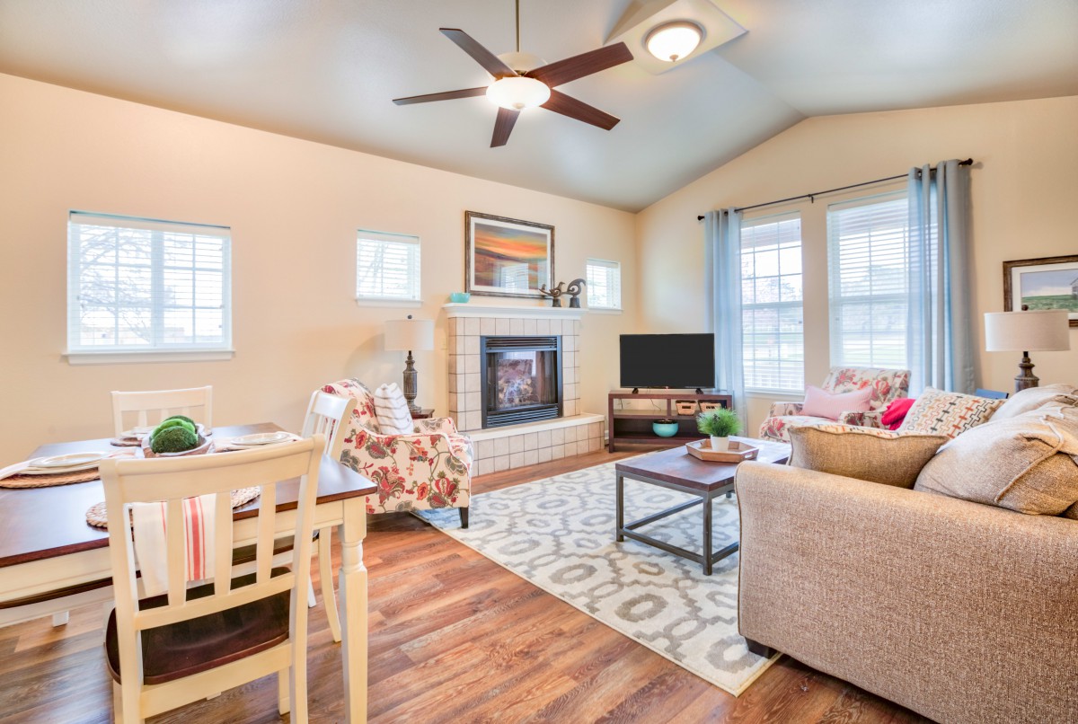 A cozy living room with a ceiling fan, fireplace, and comfortable seating.