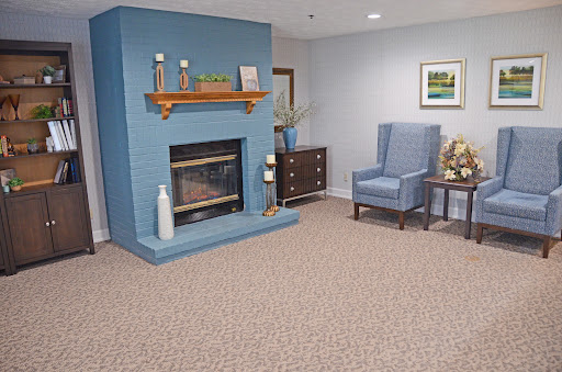 A cozy living room featuring a blue accent wall, a fireplace, and comfortable seating.