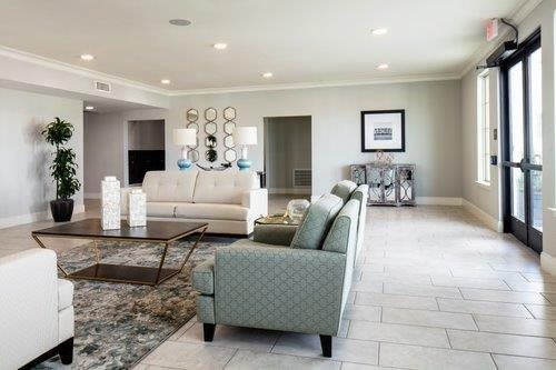 A spacious and elegantly designed living room with sofas, armchairs, a coffee table, and decorative artwork.