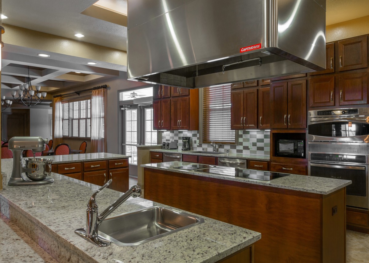 A modern kitchen with granite countertops and stainless steel appliances.