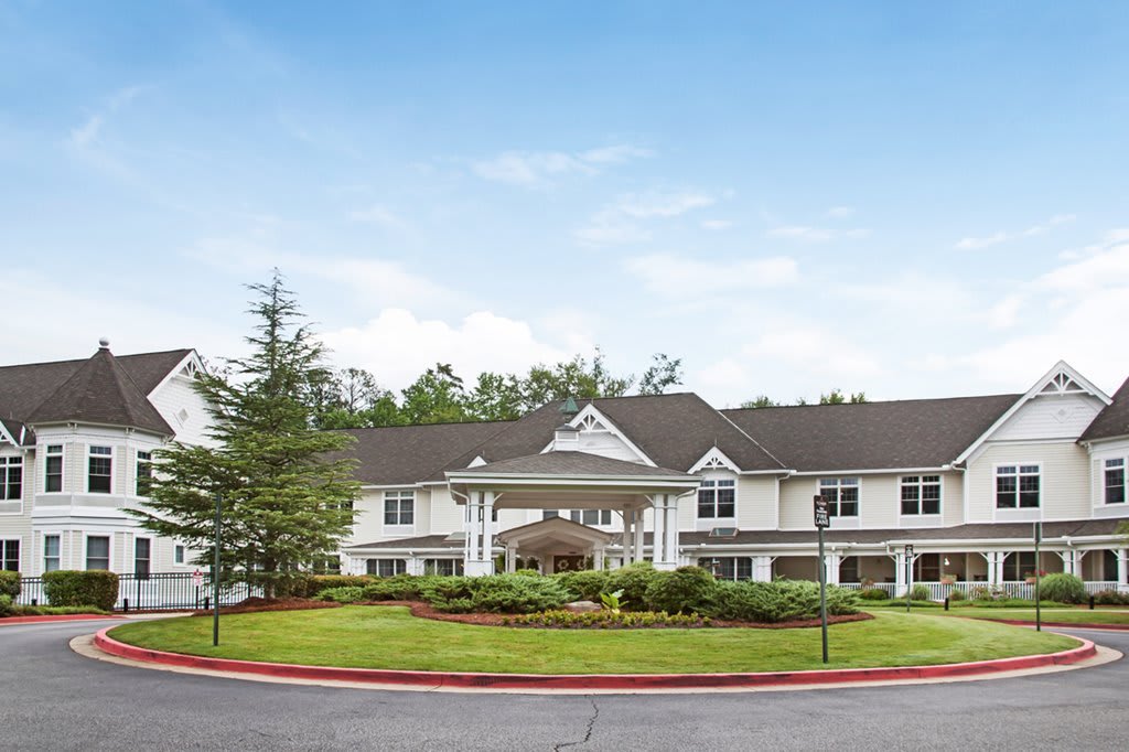 A large residential building with landscaped surroundings and a clear blue sky.