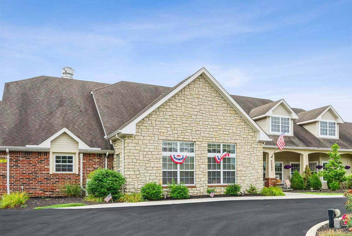 A residential building with a stone facade and well-maintained landscaping.