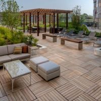 A stylish outdoor patio area featuring comfortable seating and wooden tile flooring.
