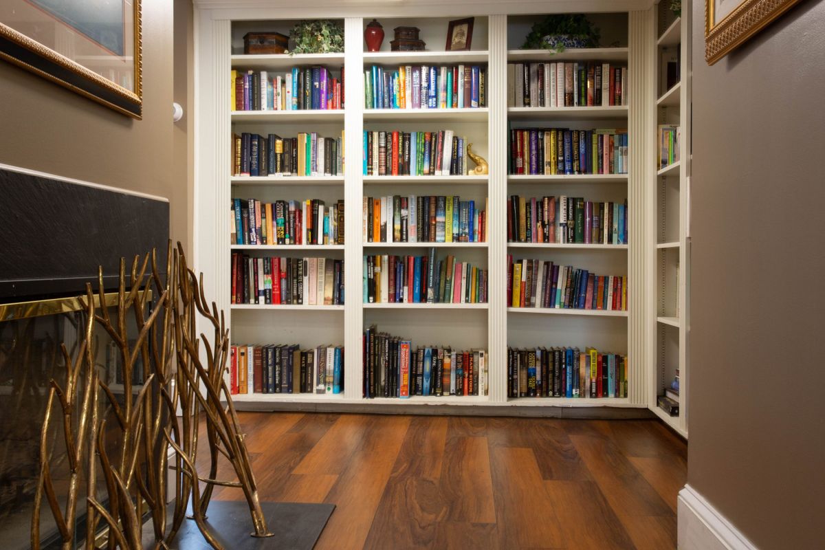 A cozy library with a neatly arranged bookshelf filled with books.