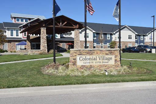 Colonial Village entrance with flags and welcoming signage.