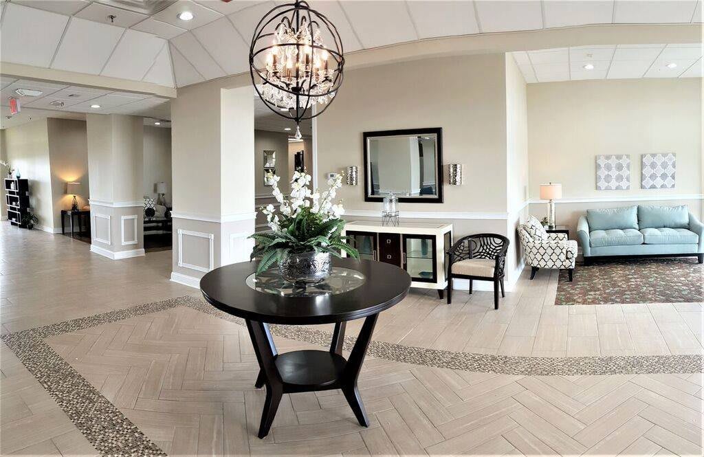 A stylish lobby area with a round table, chandelier, and elegant decor.