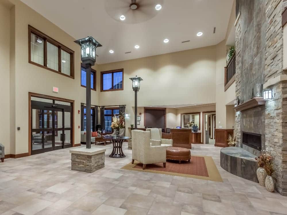 A spacious and elegantly designed hotel lobby with a reception desk, seating area, and fireplace.