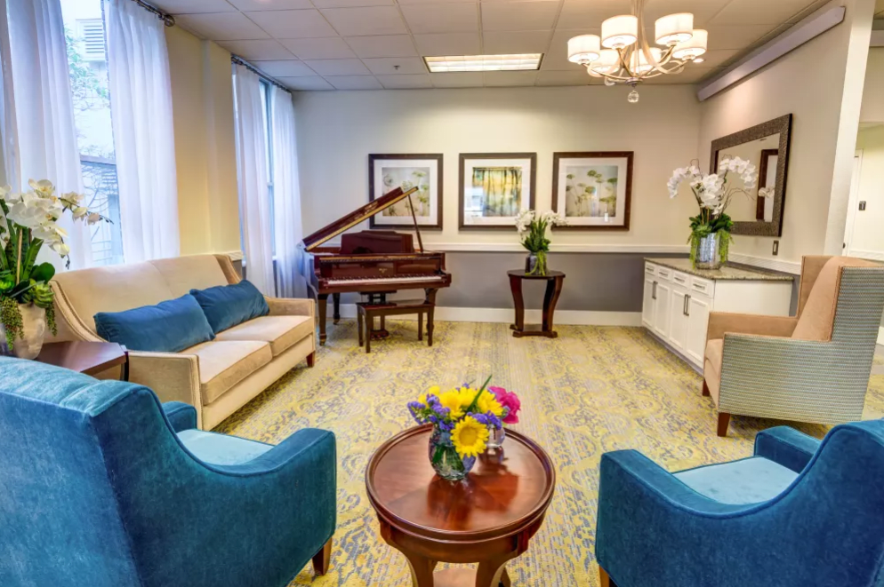 A well-furnished lobby with a piano, comfortable seating, and decorative elements.
