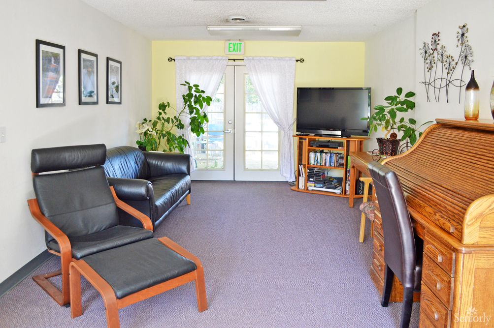 A cozy living room with comfortable seating, plants, and a TV for entertainment.