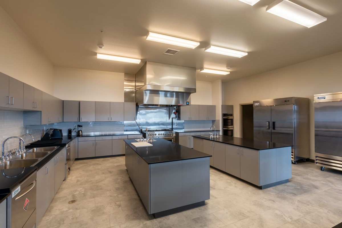 A spacious modern commercial kitchen with stainless steel appliances and ample counter space.