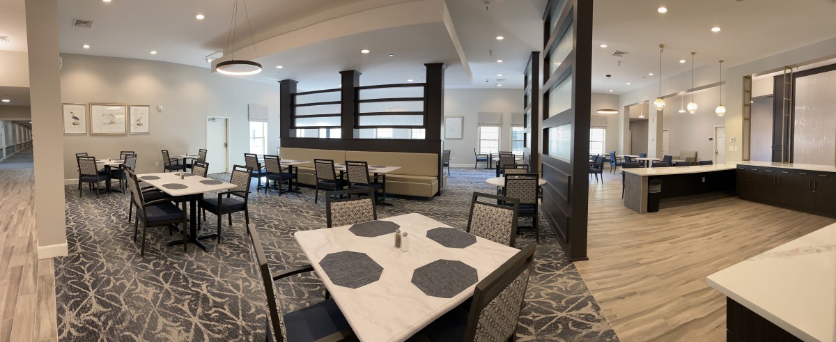 A modern dining area with neatly arranged tables and chairs, featuring contemporary interior design elements.