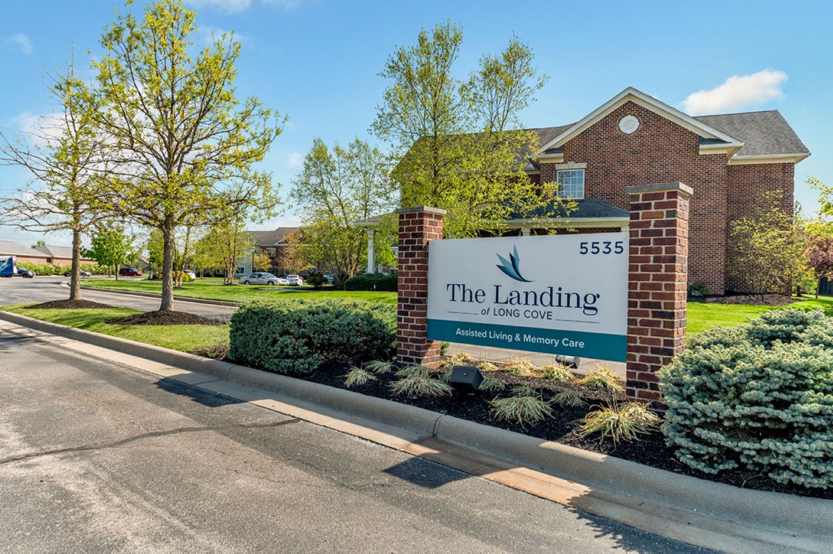 Entrance sign for The Landings apartment complex surrounded by greenery.