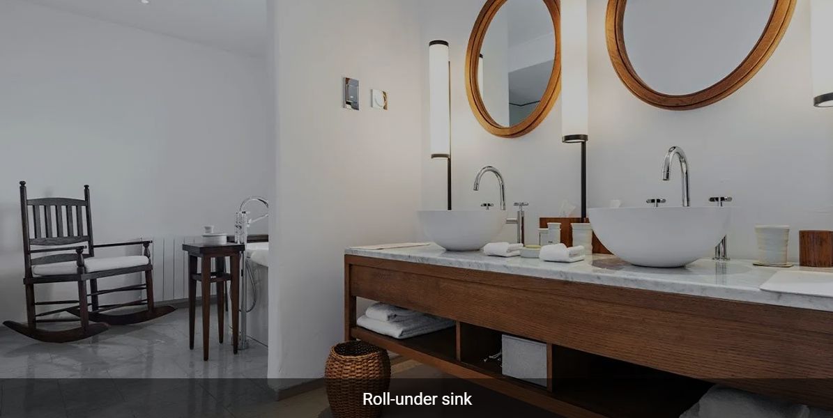 A modern bathroom with a wooden sink vanity and round mirrors.