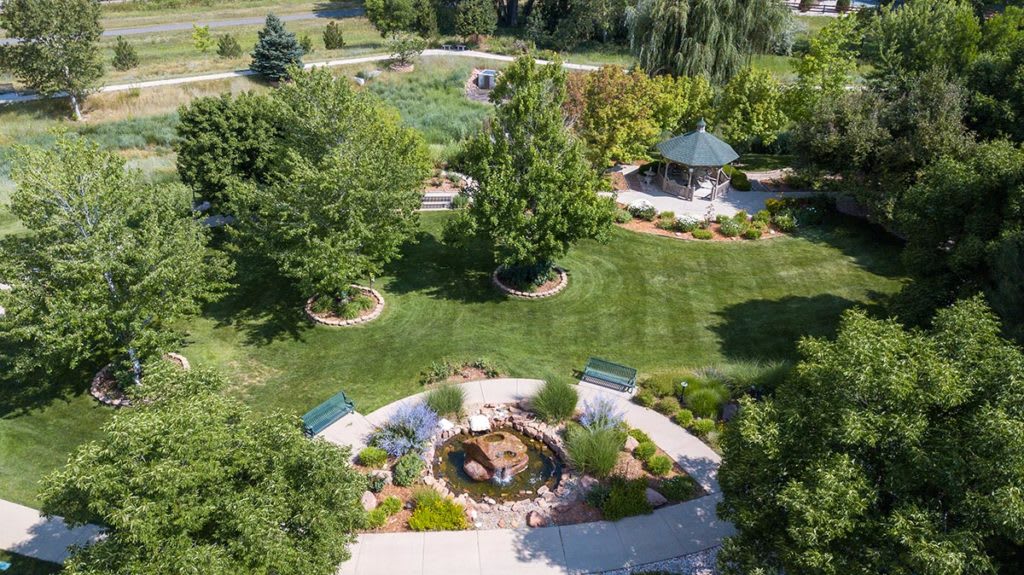 Aerial view of a beautifully landscaped garden featuring a gazebo, pond, and lush greenery.