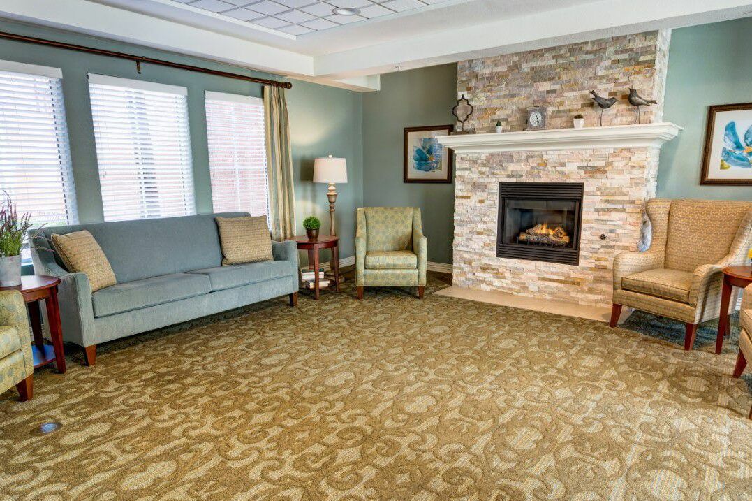 A cozy living room with a stone fireplace and comfortable seating.