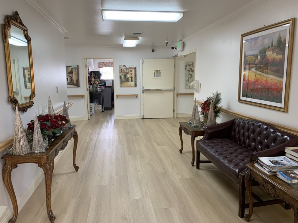 An elegantly decorated hallway with paintings on the walls and a wooden floor.