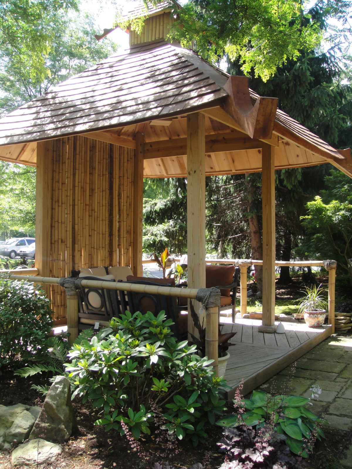 A traditional Japanese garden structure surrounded by lush greenery.