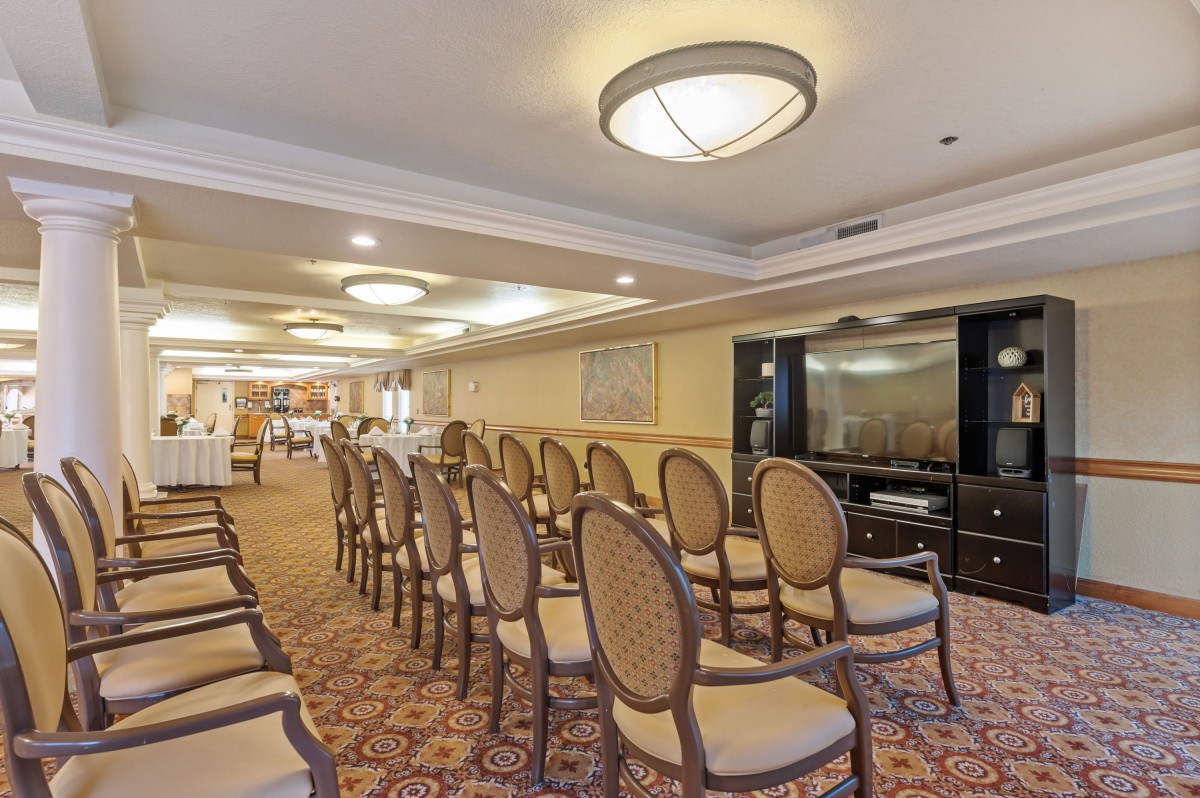 A well-lit conference room with rows of chairs set up for a meeting or event.